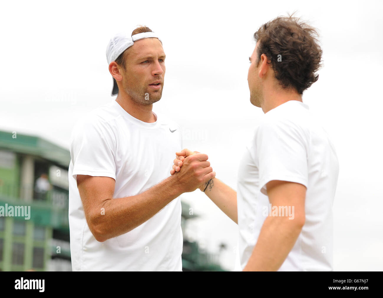 Lukasz Kubot (à gauche), en Pologne, serre la main avec Adrian Mannarino, en France, après avoir remporté leur match au cours du septième jour des championnats de Wimbledon au All England Lawn tennis and Croquet Club, Wimbledon. Banque D'Images