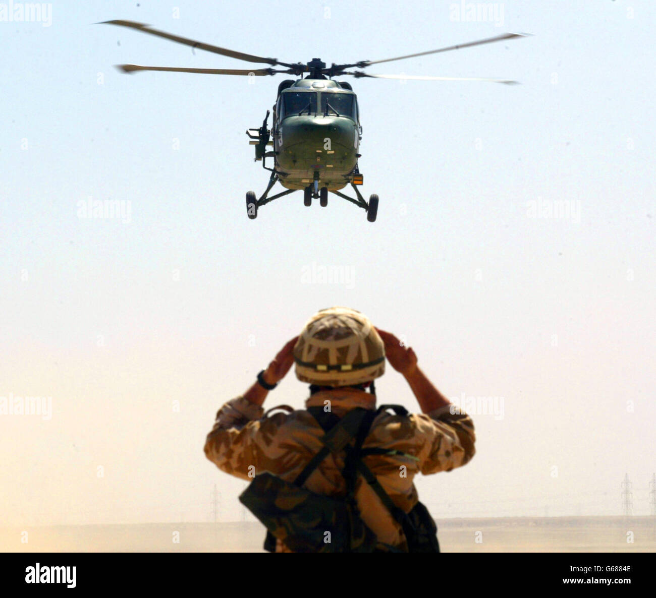 Membre du corps d'assaut du 3e Régiment, 16 Brigade d'assaut de l'Air, regarde un hélicoptère Lynx du 653 Escadron au Koweït. Banque D'Images