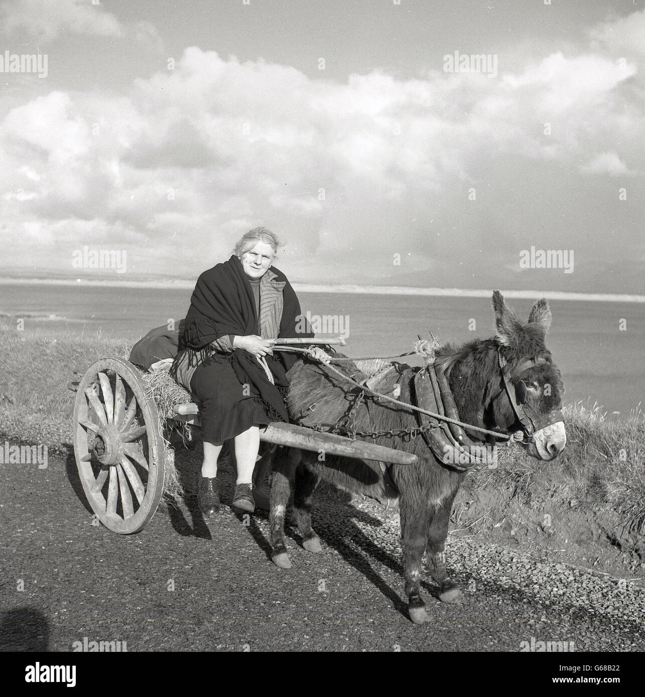 Années 1950, historiques, pays dame assise à côté selle sur l'âne et le panier, de l'Irlande. Banque D'Images