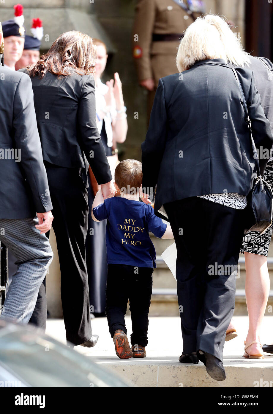 Rebecca Rigby (à gauche), épouse de Fusilier Lee Rigby assassiné, arrive en tenant la main de leur fils Jack, pour son service funéraire à l'église de la paroisse de Bury dans le Grand Manchester. Banque D'Images