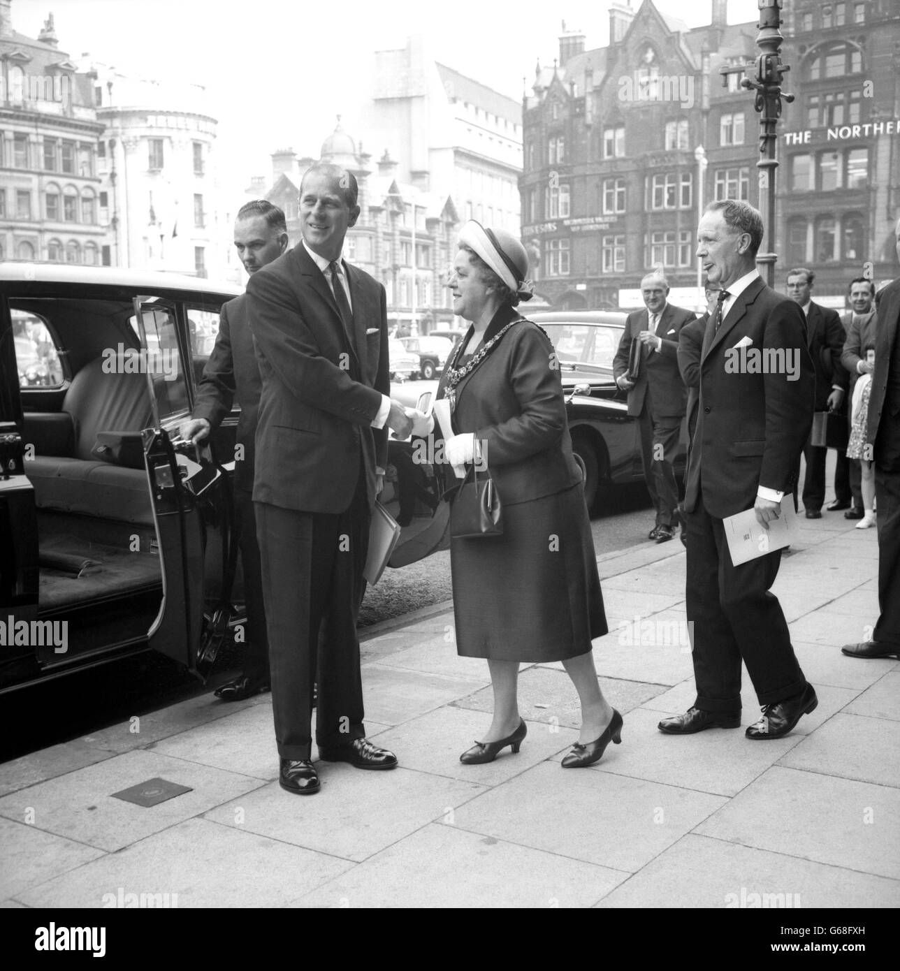 Le prince Philip, duc d'Édimbourg, se tourne avec le sourire pour reconnaître les cris d'un « joyeux anniversaire », Monsieur, il a 45 ans, alors qu'il est accueilli par le maire de Manchester, Alderman Mme Nellie Beer, devant l'hôtel de ville de Manchester,Où il assistait à la troisième réunion biennale du Conseil général du Prix du duc d'Édimbourg. Banque D'Images