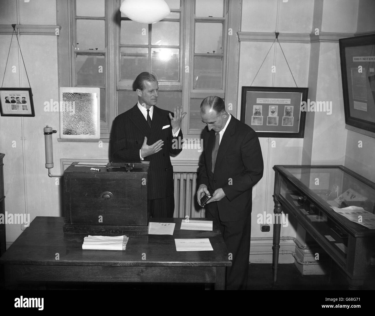 Le prince Philip, duc d'Édimbourg, se rend compte de sa main lorsque ses empreintes sont prises dans le département des empreintes digitales lors de sa visite à New Scotland Yard, Londres. Avec lui est le surintendant S. Drew du département. Banque D'Images