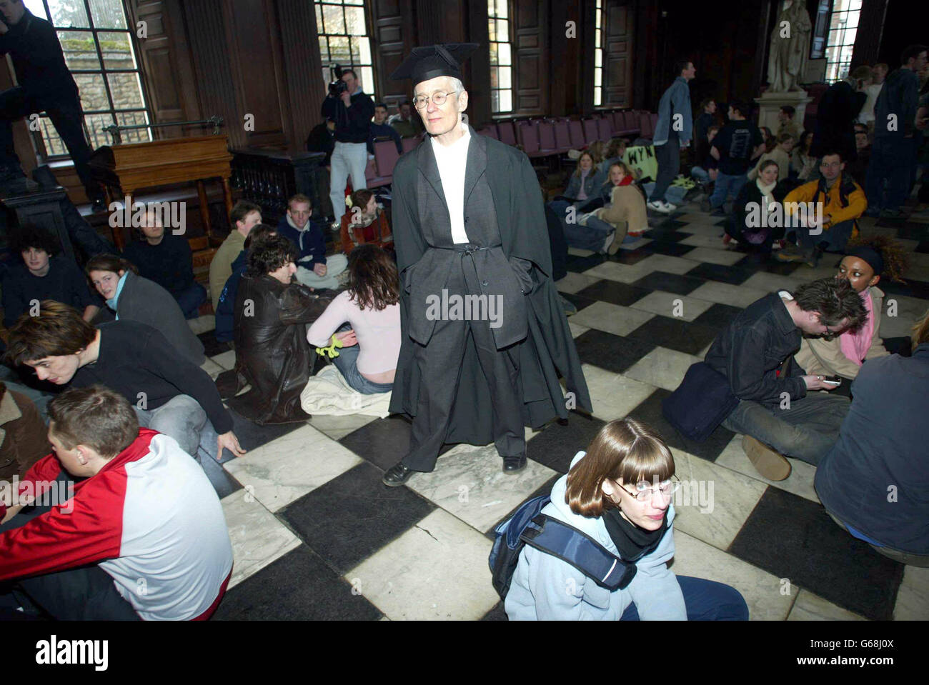 Un procter se promène au milieu de la manifestation, alors que les étudiants de l'université de Cambridge se rappelaient des protestations du passé en organisant un sit-in contre les plans du gouvernement d'introduire des frais de supplément. * environ 100 étudiants ont occupé la maison du Sénat de l'Université de Cambridge - le bâtiment où des cérémonies de diplômes sont tenues dans le centre de la ville - en protestation contre les réformes de financement de l'enseignement supérieur proposées par le secrétaire à l'éducation Charles Clarke. Banque D'Images