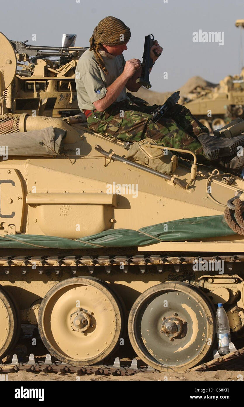 Un membre de la Royal Scots Dragoon Guards inspecte son équipement dans le désert du Koweït avant une éventuelle action militaire. Banque D'Images