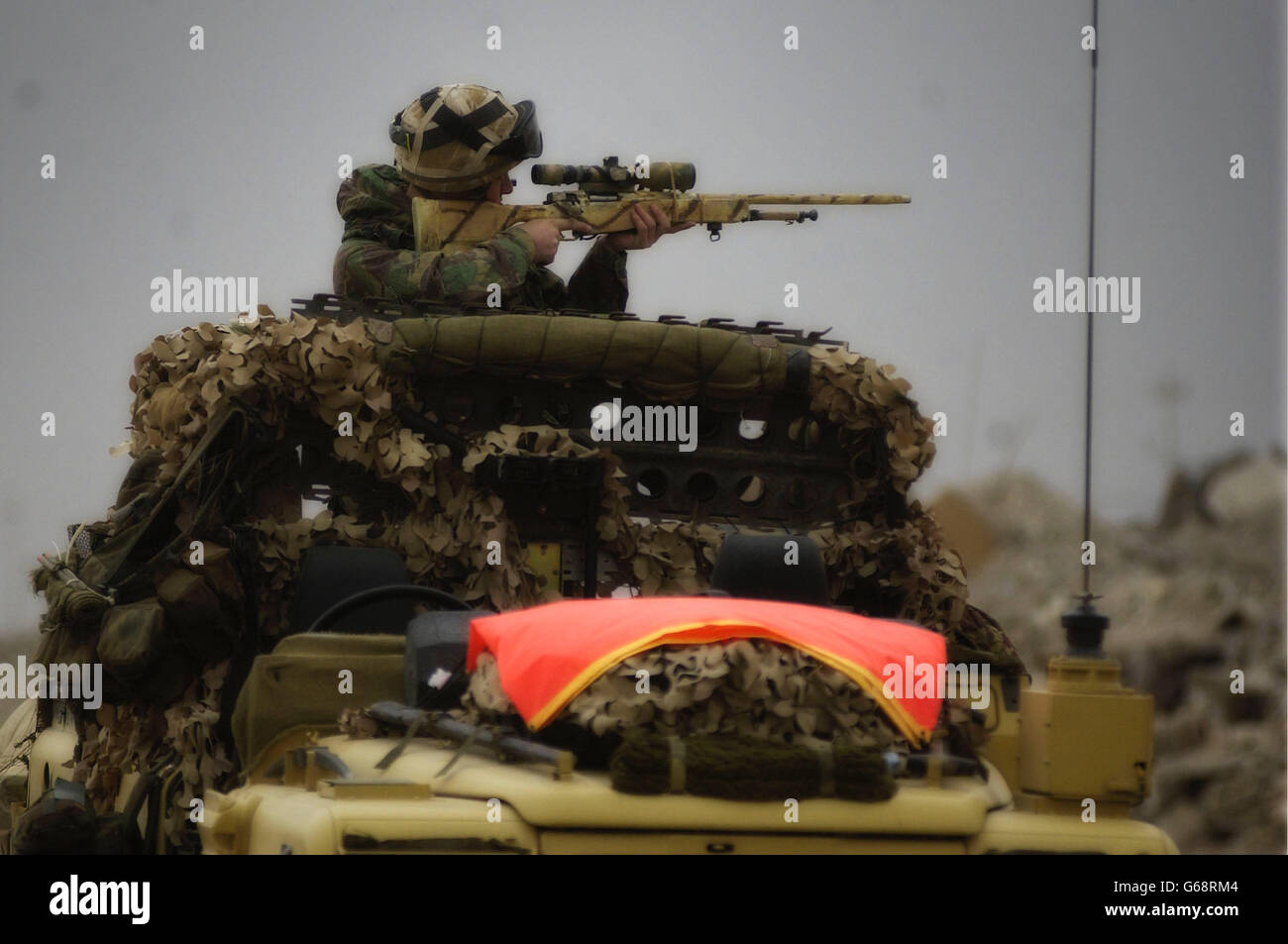 Un sniper du 51 Sqn RAF Regiment, utilise un landrover dépouillé comme point de tir. Banque D'Images