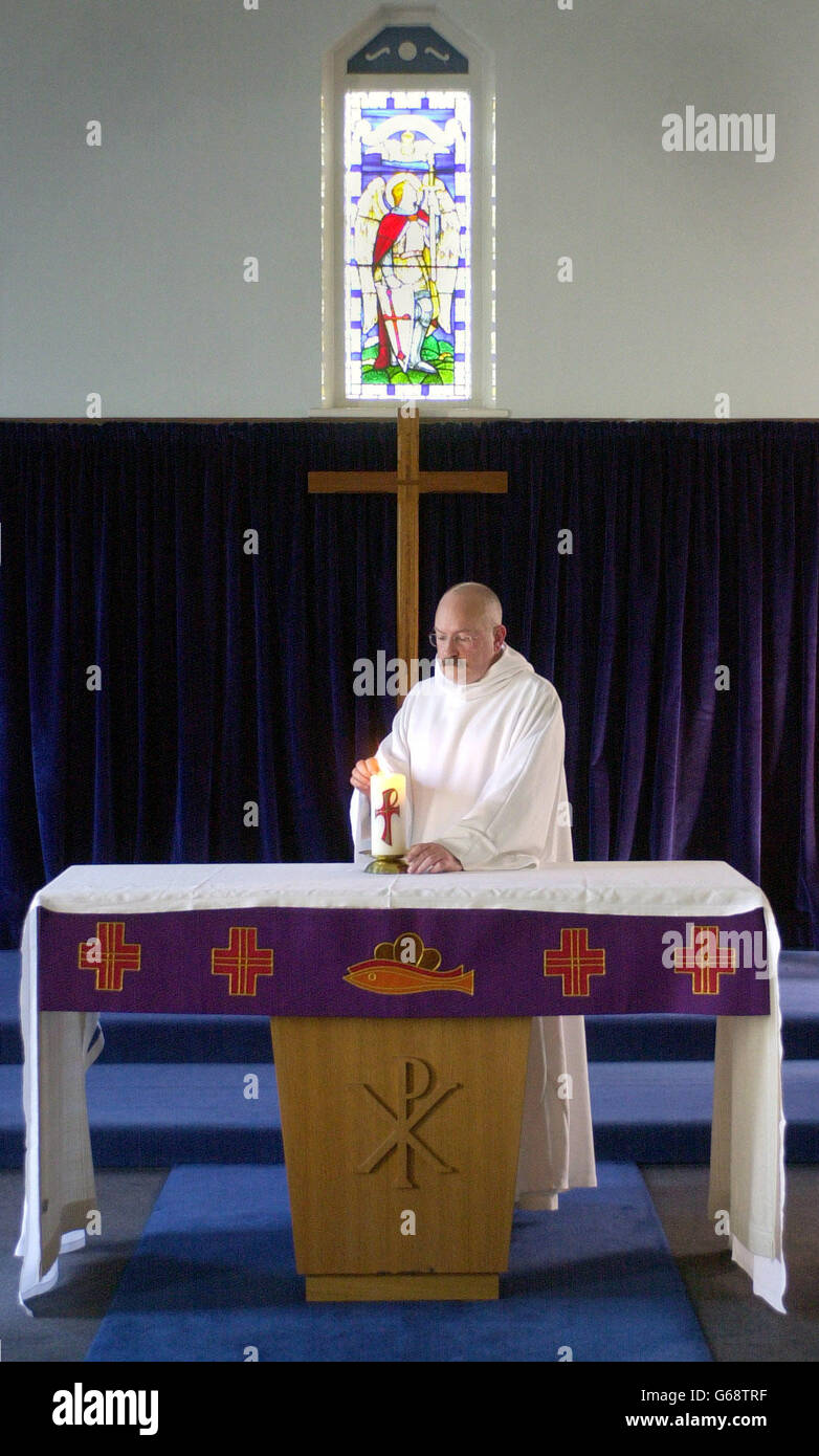 Le révérend William Mounsey, aumônier anglican de la RAF Leuchers, Leuchers, Fife. Il est photographié éclairant une bougie pour la paix dans l'église St Paul et St Michaels à la base . Banque D'Images