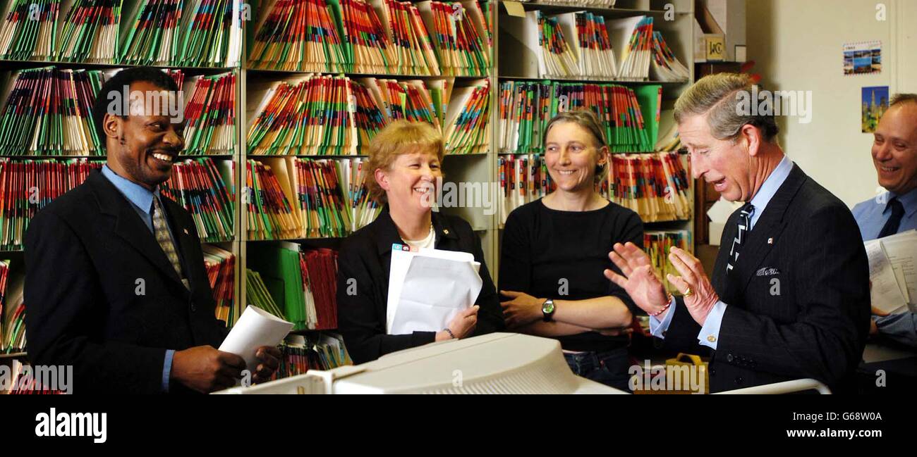 Le Prince de Galles, visite la Croix-Rouge à Londres. Après la mort de sa grand-mère, la reine mère, l'année dernière, il a pris le rôle de président de cette œuvre de bienfaisance. Le Prince Charles s'entretient avec Albino Okello, un agent de recherche de cas (à l'extrême gauche). Banque D'Images