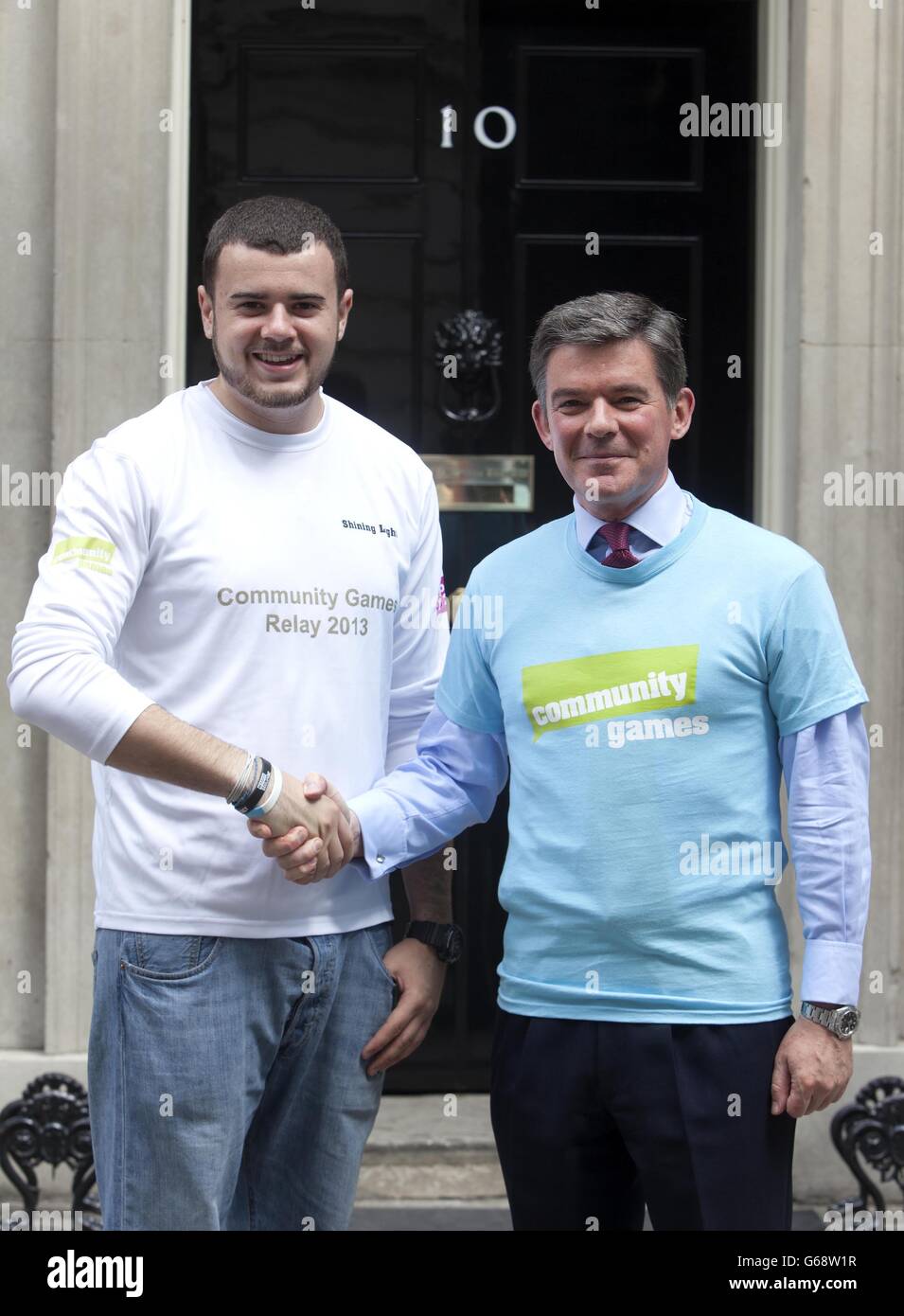 Le ministre des Sports, Hugh Robertson (à droite), présente le jeune ouvrier de 20 ans, Anthony Temple, de Bermondsey, dans le sud de Londres, avec un maillot commémoratif Shining Light le 69e jour du Relais des Jeux communautaires, Qui reflète la route du relais de la flamme olympique à travers l'Angleterre, à l'extérieur du 10 Downing Street dans le centre de Londres. Banque D'Images