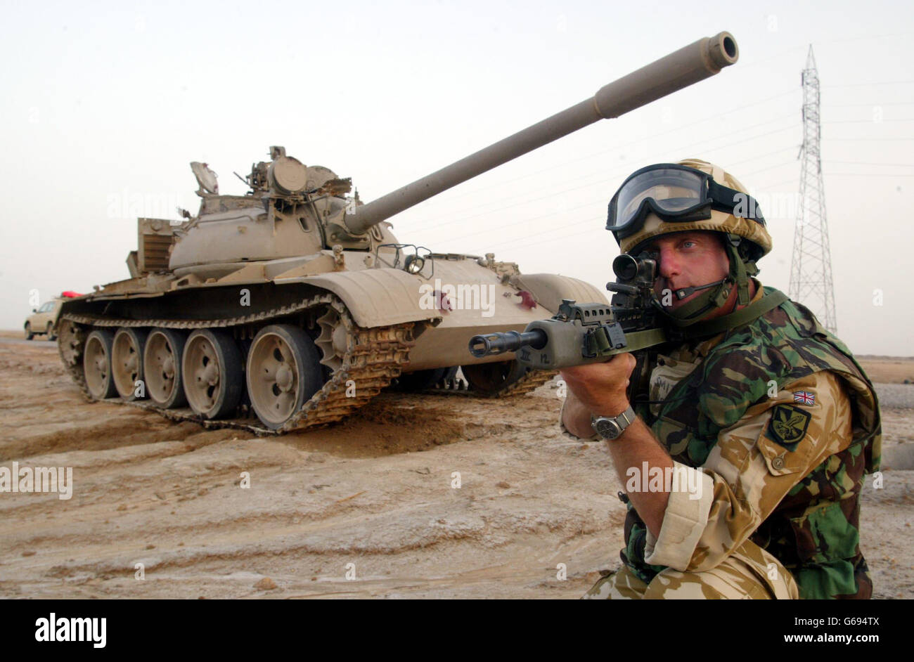 T55 chars inspectés par les soldats du 3 Régiment corps d'aviation de l'Armée de terre, 16 Pont d'assaut de l'Air comme ils se trouvent sur le bord de la route, les chars ont été bombardés par les Forces de coalition. Banque D'Images