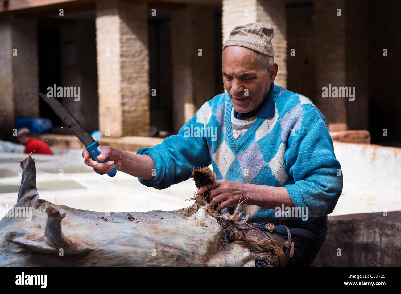 Fes, Maroc - 11 Avril 2016 : un homme travaillant dans une tannerie dans la ville de Fès au Maroc. Banque D'Images