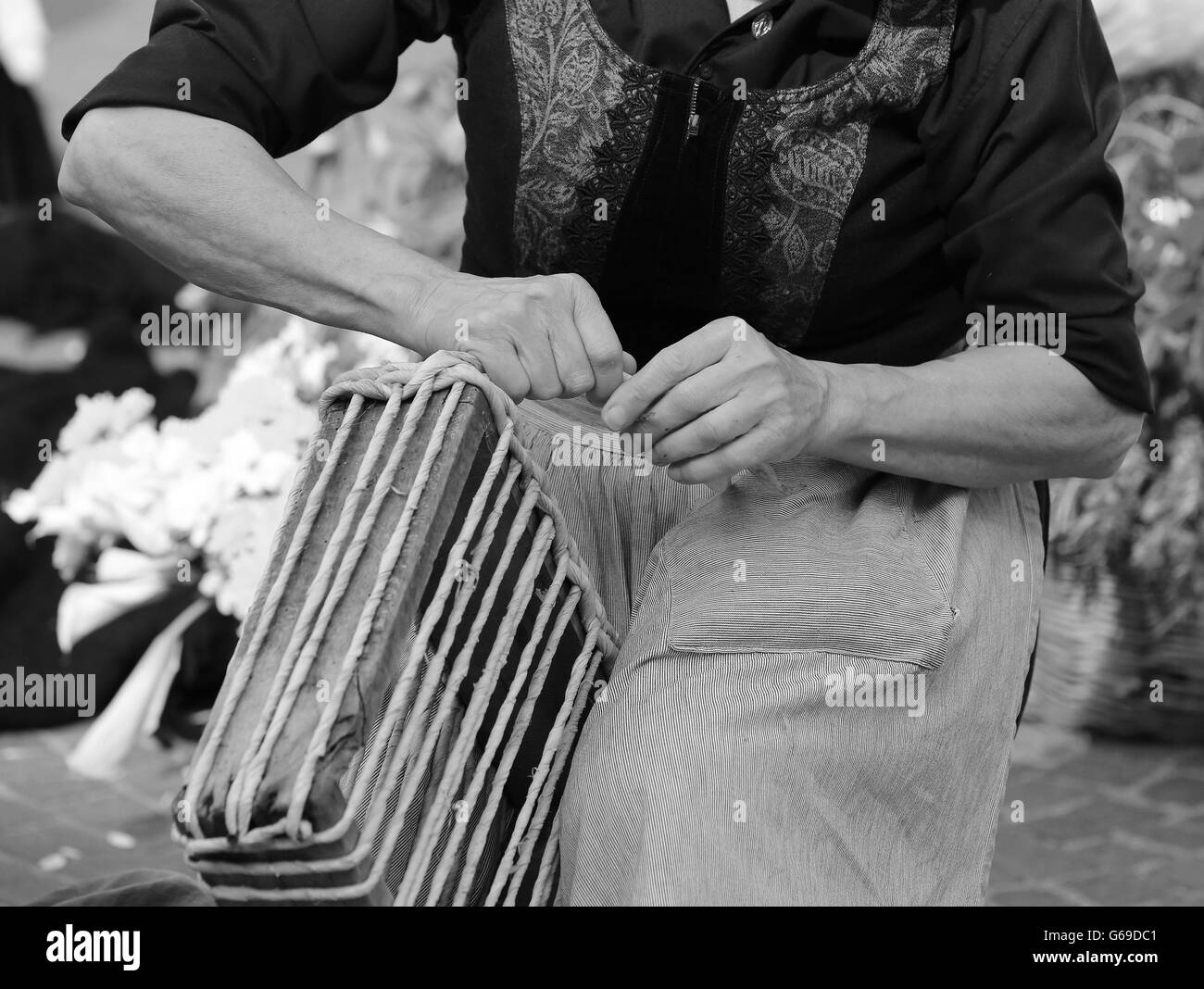 Vieille Femme travailler avec ses mains liées de la paille pour créer un beau sac fait main Banque D'Images