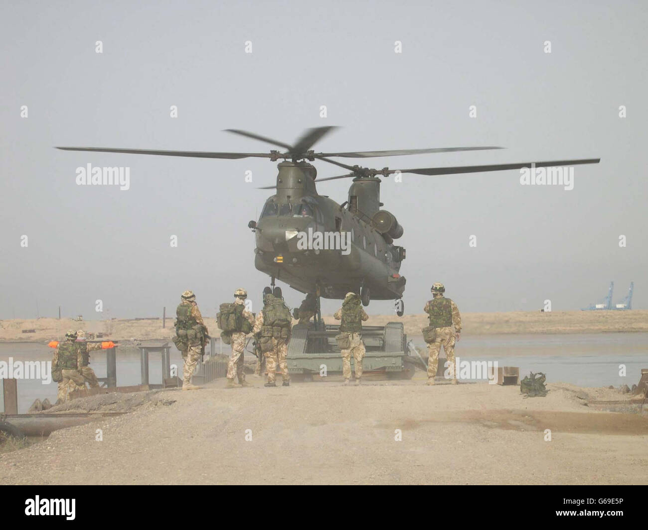 Un hélicoptère Chinook est étonnamment bas car il permet de descendre un pont mobile au bon endroit sur les rives du Shat Al Basra, en face d'Umm Qasr dans le sud de l'Irak. * les Royal Engineers formés au Commando sont entrés dans les livres d'histoire quand ils ont volé dans la zone de bataille d'Umm Qasr pour construire un pont d'approvisionnement vital. Les troupes, principalement des réservistes, du 131 Escadron Commando indépendant, ont été aérolevées sur les berges de la voie navigable Shat Al Basra, à la périphérie de la ville portuaire du sud de l'Iraq, durant les premières heures. Banque D'Images