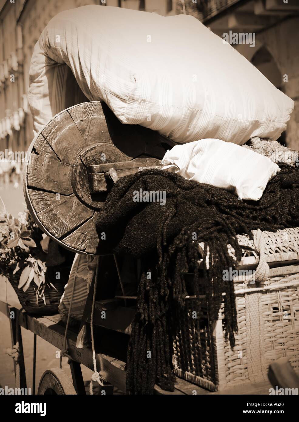 Ancien panier d'un matelas et d'autres éléments de la famille d'immigrants pauvres en effet sépia Banque D'Images