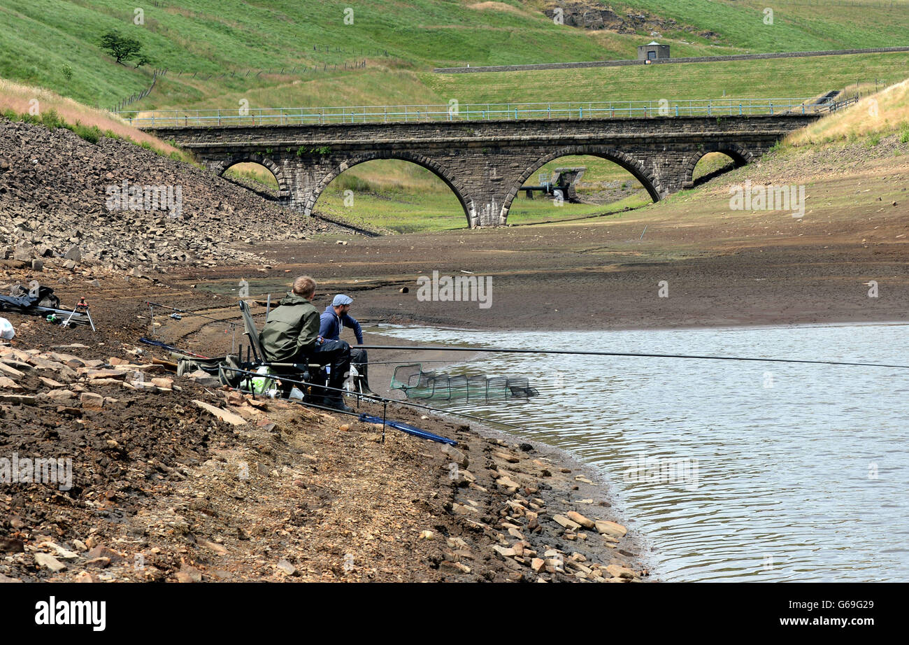 Les gens pêchent dans le réservoir de dot près d'Oldham, alors que les niveaux d'eau reculent en raison du temps chaud et sec dans tout le Royaume-Uni au cours des dernières semaines. Banque D'Images