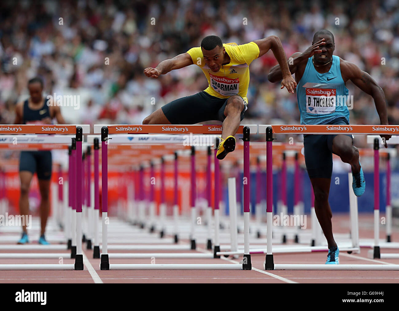 William Sharman (au centre) de Grande-Bretagne en action pendant la finale hommes haies de 110 mètres après la chute de l'américain Aries Merritt (à gauche) au cours du deuxième jour de la réunion de l'IAAF London Diamond League au stade olympique de Londres. Banque D'Images