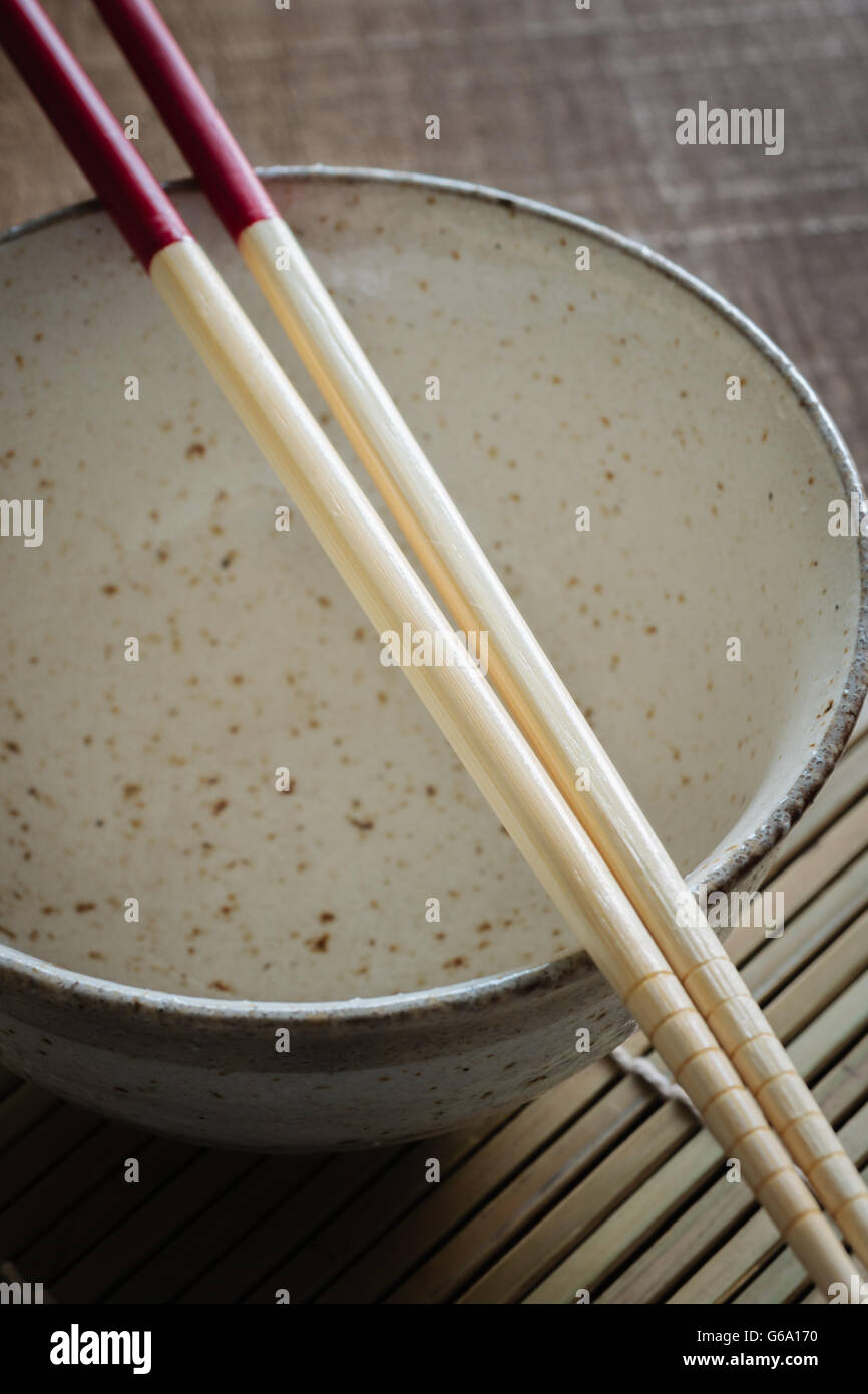 Céramique japonaise ou bol de nouilles de riz avec des baguettes en bambou traité rouge tourné avec slective focus Banque D'Images