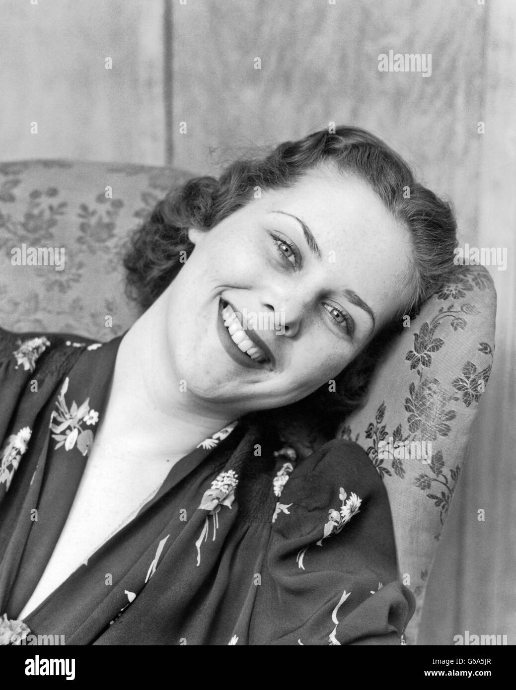 Années 1930 Années 1940 PORTRAIT SMILING BRUNETTE WOMAN VOUS PENCHER SUR LE CÔTÉ ARRIÈRE DE L'AILE CONTRE PRÉSIDENT LOOKING AT CAMERA Banque D'Images