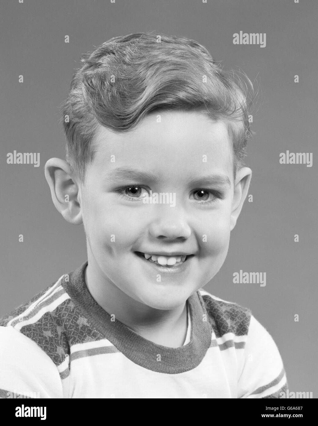 1950 PORTRAIT SMILING BOY LOOKING AT CAMERA WEARING TEE SHIRT RAYÉ Banque D'Images