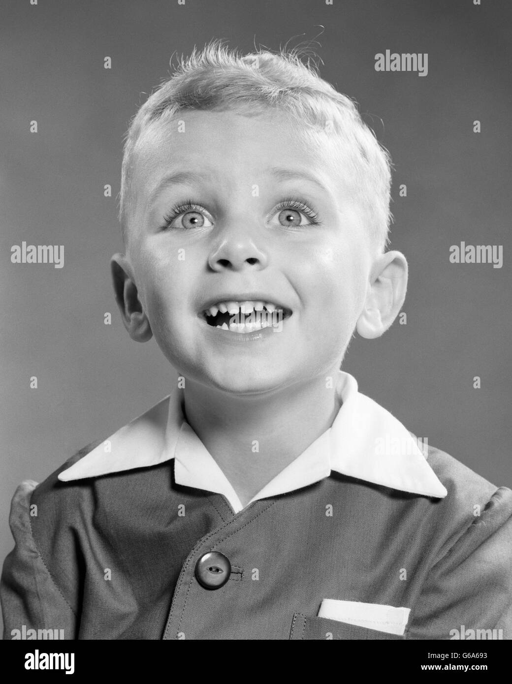 1950 PORTRAIT SMILING BLONDE BOY LOOKING UP AT CAMERA excité Banque D'Images