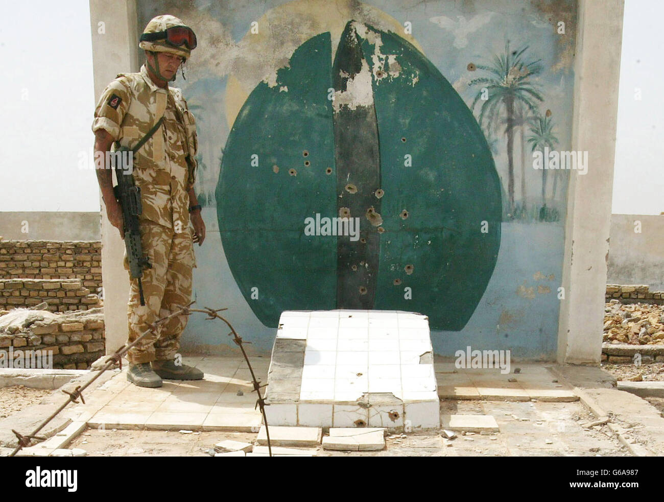 Un soldat examine ce qui a été décrit par l'un de ses collègues comme une « galerie de tir construite sur mesure », découverte avec des restes humains et des cercueils dans une base irakienne abandonnée près de Bassorah. Des centaines de restes humains ont été découverts dans une morgue de fortune. DaN Chung / Guardian / MOD Pool. *... par des soldats britanniques dans le sud de l'Irak. Les crânes, paquets d'os en bandes d'uniforme militaire, ont été jetés dans des sacs en plastique et des cercueils non scellés dans une base militaire irakienne abandonnée à la périphérie d'Al Zubayr. Il était impossible de dire combien de temps les restes étaient là mais la sombre découverte Banque D'Images