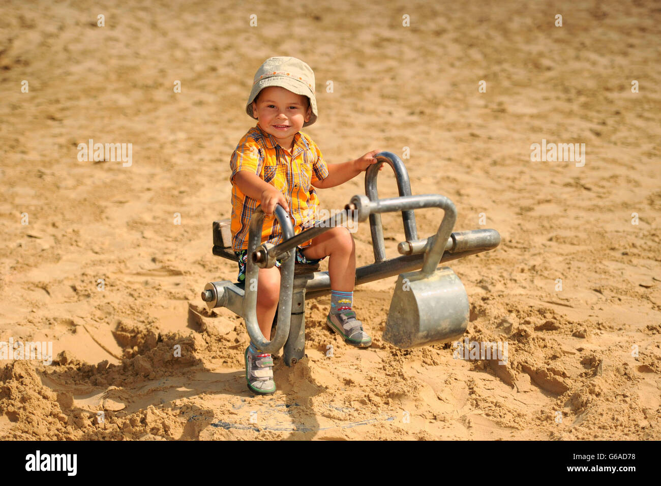 Lucas Hardacre, âgé de 2 ans, bénéficie du temps ensoleillé dans la fosse de sable de York Maze, dans le North Yorkshire. Banque D'Images