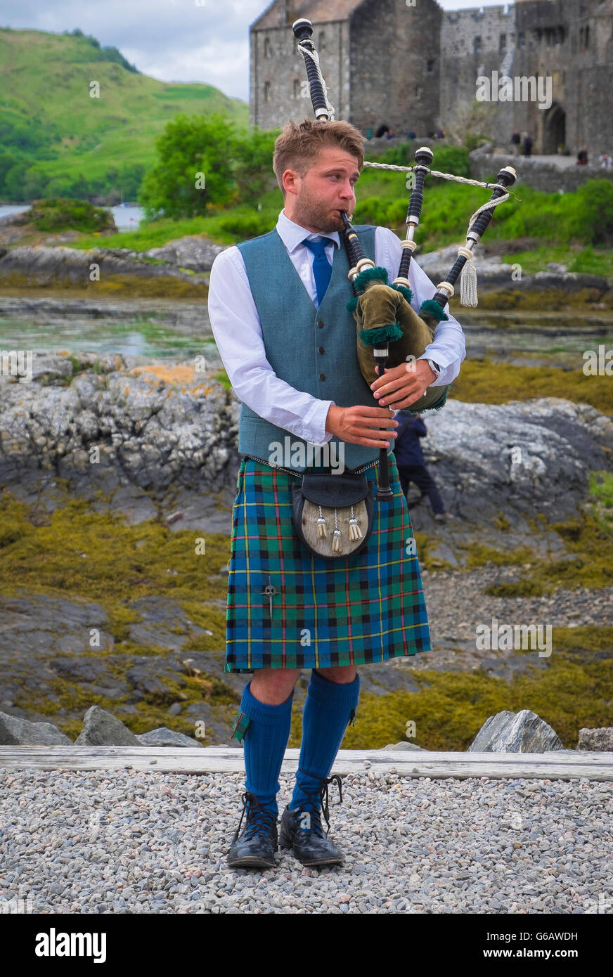 Jeune homme en kilt écossais traditionnel cornemuse avec devant le Château  d'Eilean Donan en Ecosse Photo Stock - Alamy