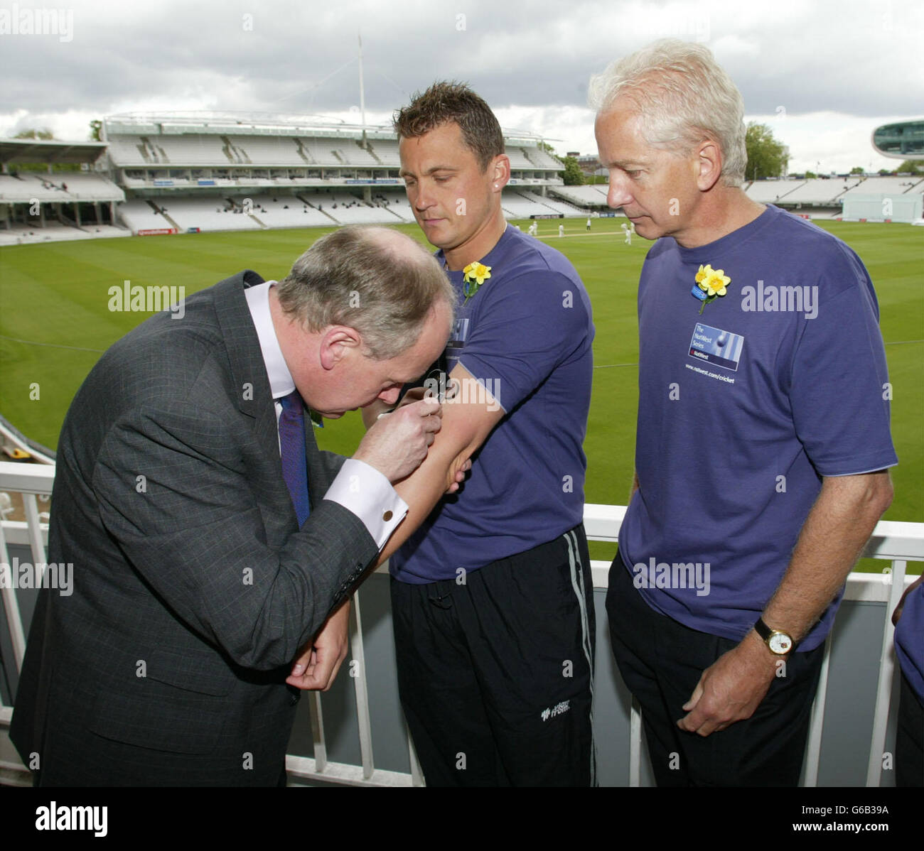 David Gower se penche sur Darren Gough qui a été sélectionné pour le cancer de la peau par le Dr Neil Walker dans le cadre de la campagne « un-Saftey connaissez vos primes » de NatWest/Marie Curie et pour lancer la semaine de sensibilisation au soleil à Lords North West Londres. Banque D'Images
