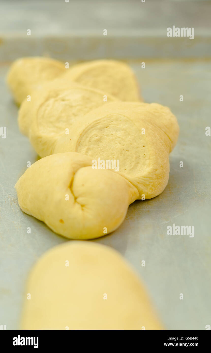 Délicieux kringle pâte prête pour four couché sur la surface de cuisson avant de métal Banque D'Images