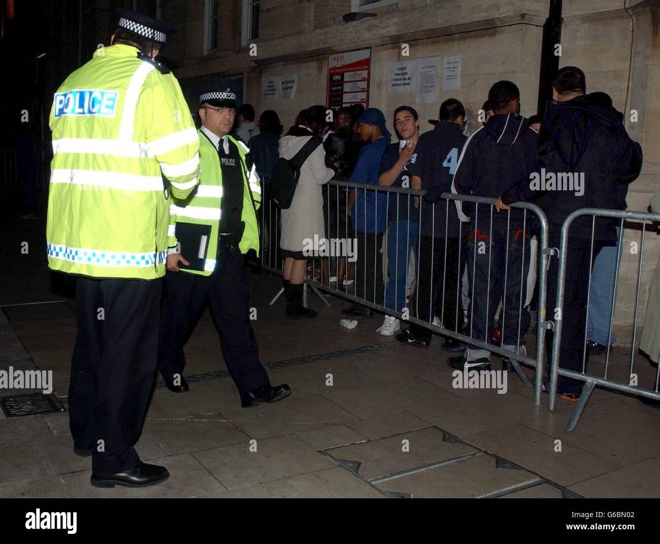 La police regarde tandis que les fans se tournent vers l'extérieur de la salle de musique Ocean, à Hackney, pour un concert de So Solid Crew. Banque D'Images