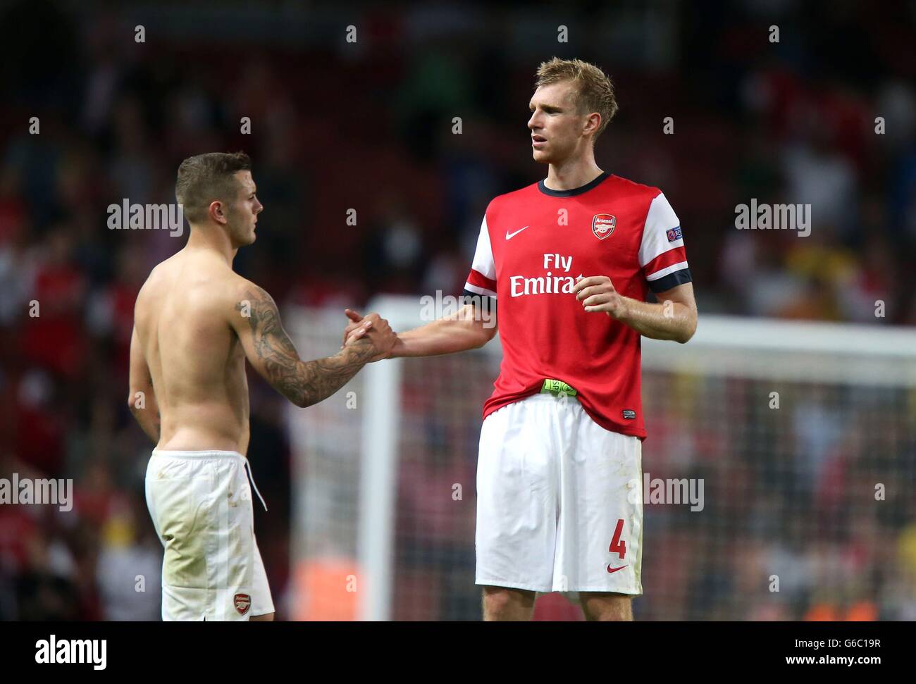 Arsenal's Per Mertesacker (à droite) et Jack Wilshere à la fin du match lors de l'UEFA Champions League, Play-off Round, second Leg au stade Emirates, Londres. Banque D'Images