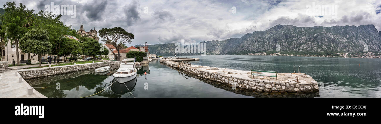 Baie de Kotor shot du bord de l'eau à Prčanj, le Monténégro. Montrant un couple des bateaux à quai et la baie sur un jour nuageux moody Banque D'Images