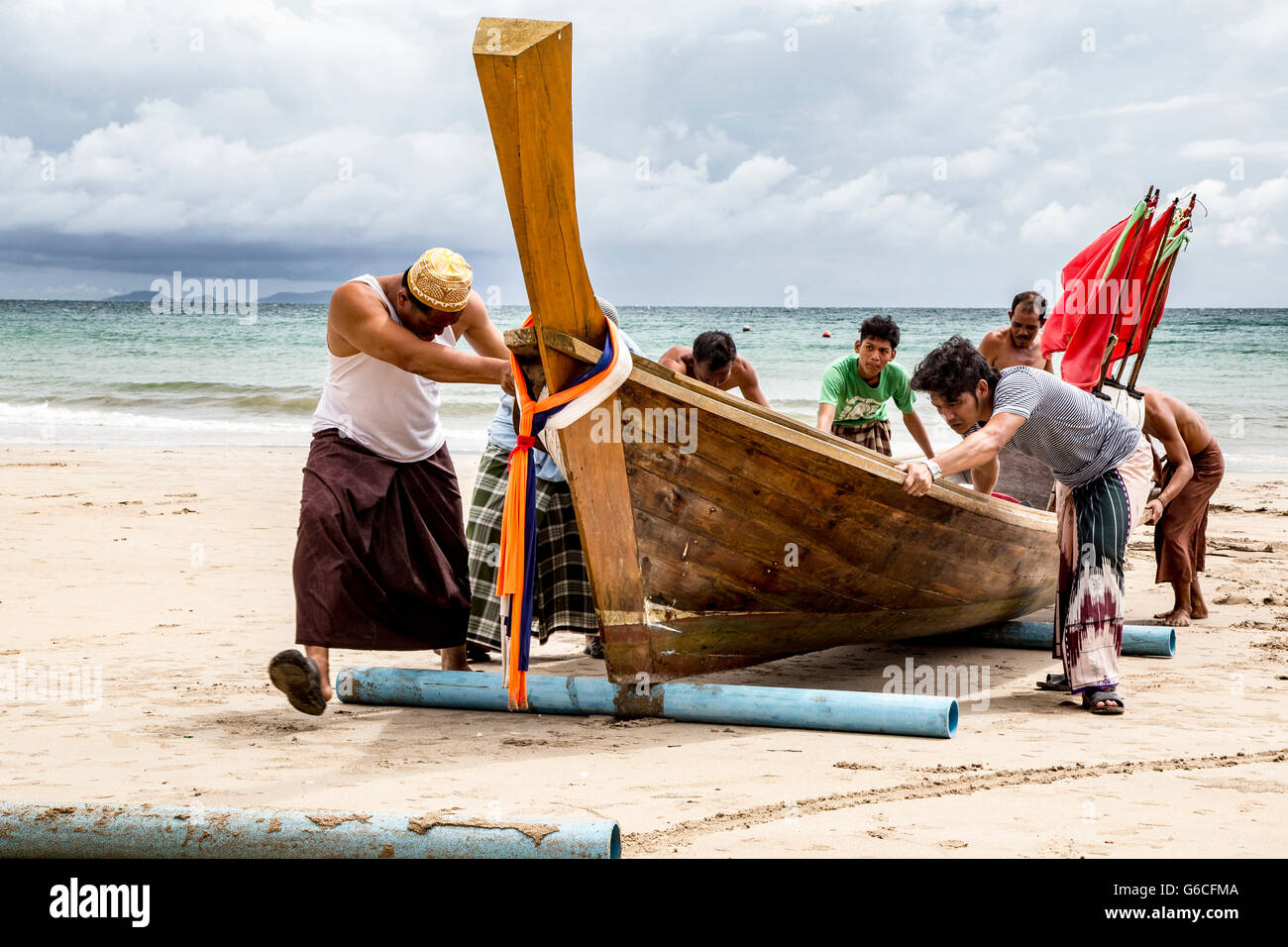 Des pêcheurs sur l'île de Koh Lanta en Thaïlande pousser vers la côte en Bateau Banque D'Images