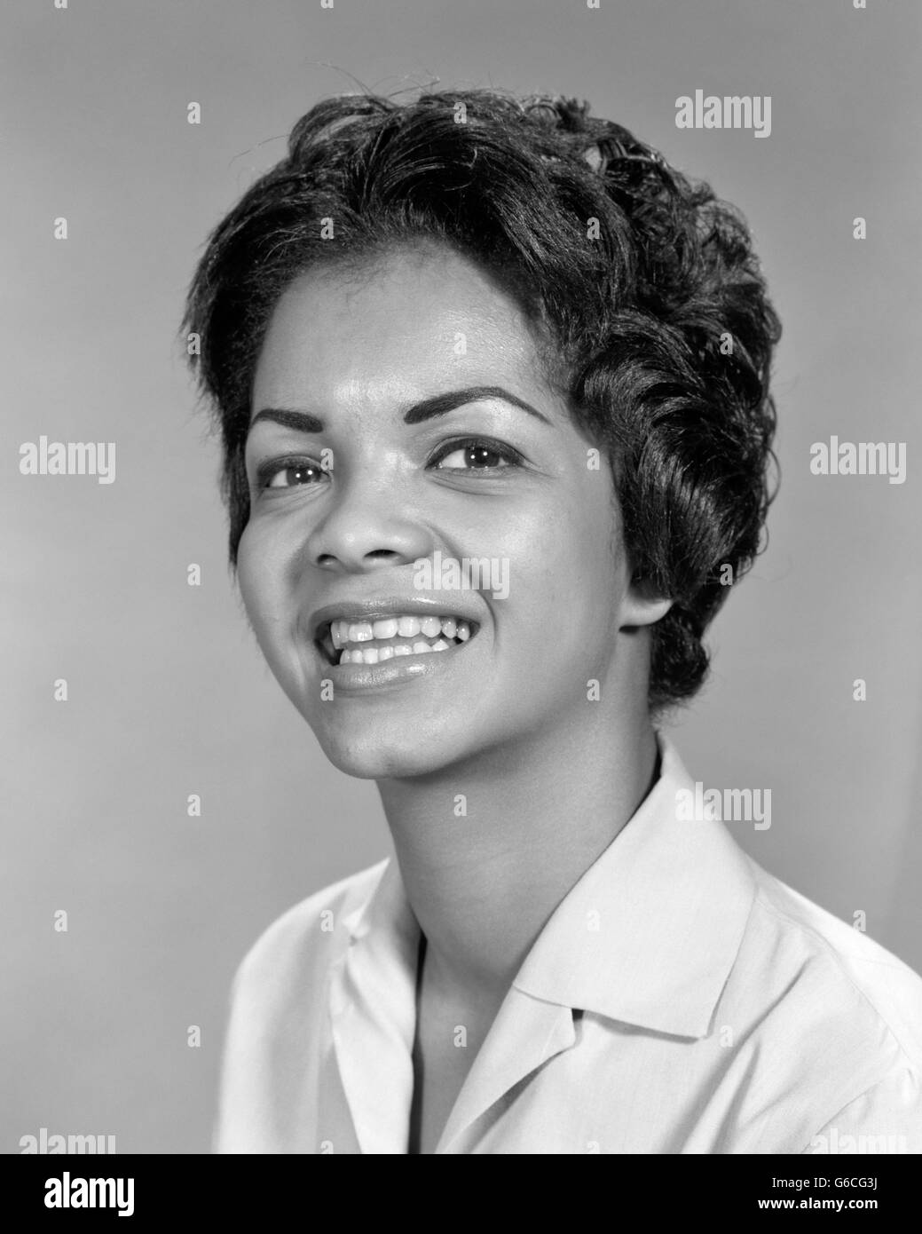 1960 PORTRAIT SMILING AFRICAN AMERICAN WOMAN LOOKING AT CAMERA Banque D'Images