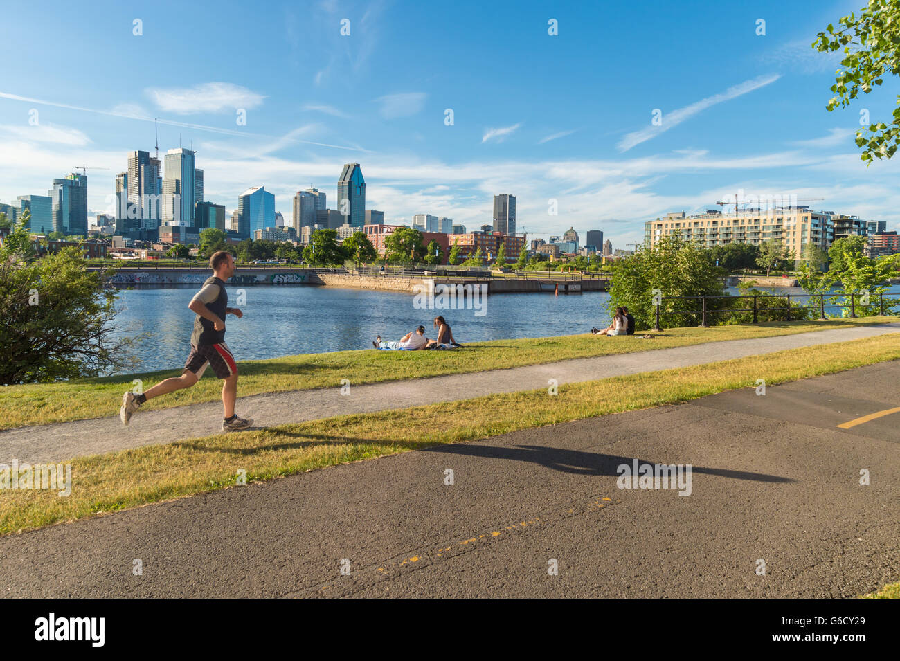 Piste cyclable du Canal de Lachine à Montréal, avec en arrière-plan et d'un jeune homme qui court Banque D'Images