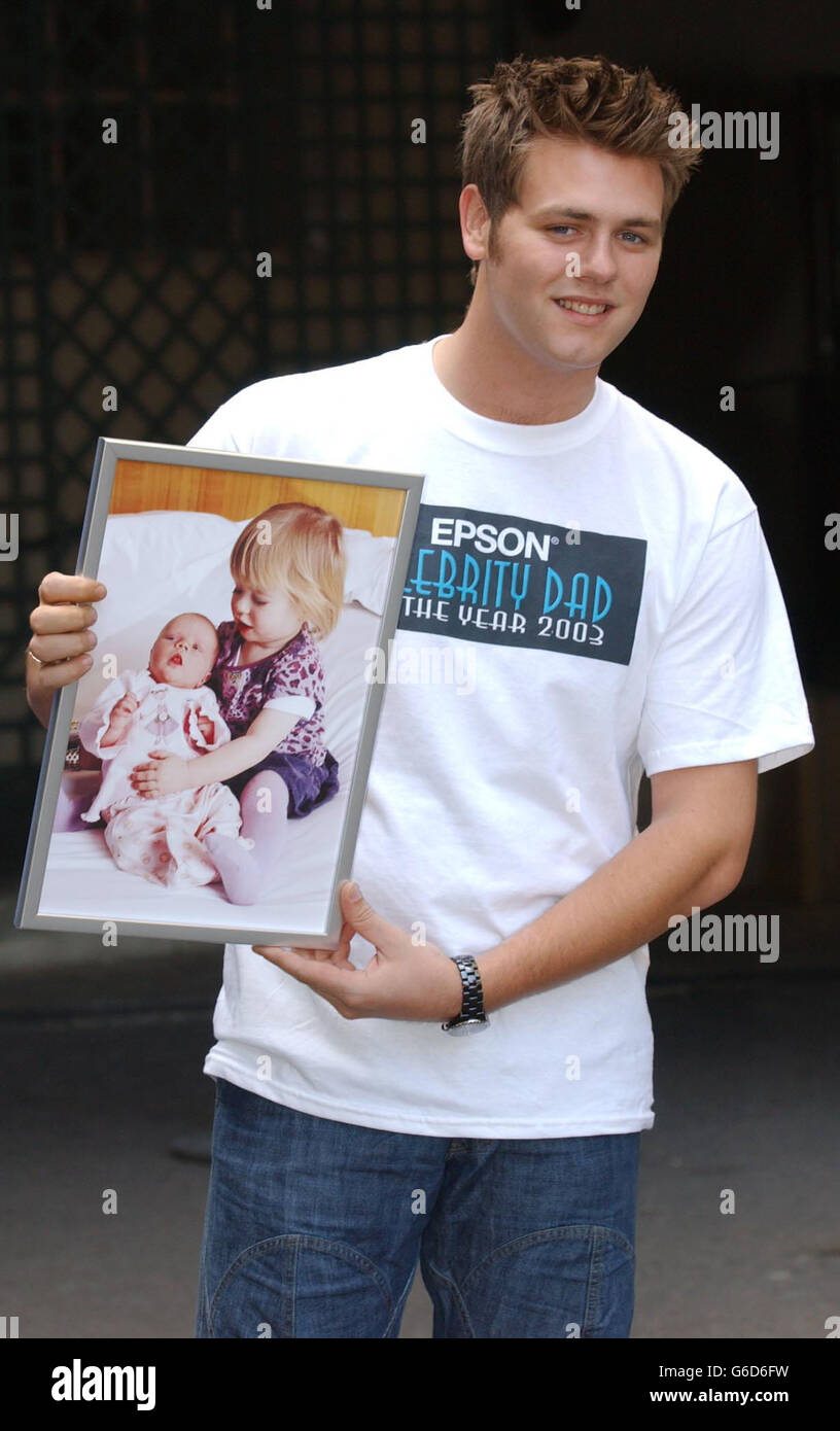 Bryan McFadden, chanteur de Westlife, pose pour les photographes une photo de ses enfants, Lilly Sue (à gauche) et Molly à l'hôtel Grosvenor House dans le centre de Londres après avoir été élu « EPSON Celebrity Dad of the Year 2003 » par le public. Banque D'Images