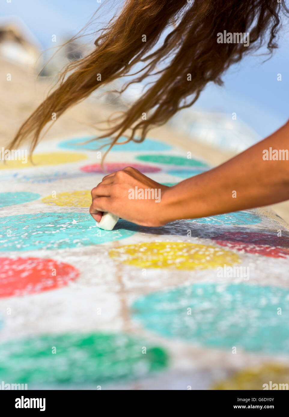 Une femme cires surfeur surf longboard sa par un jour de vent à Newport Beach, Californie Banque D'Images
