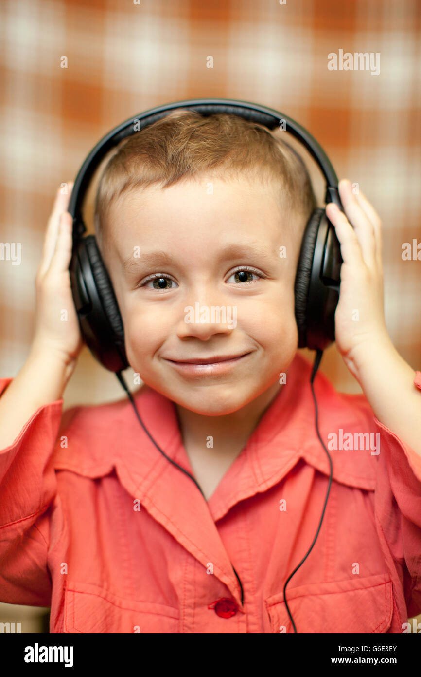 L'enfant écoute de la musique via les écouteurs Banque D'Images
