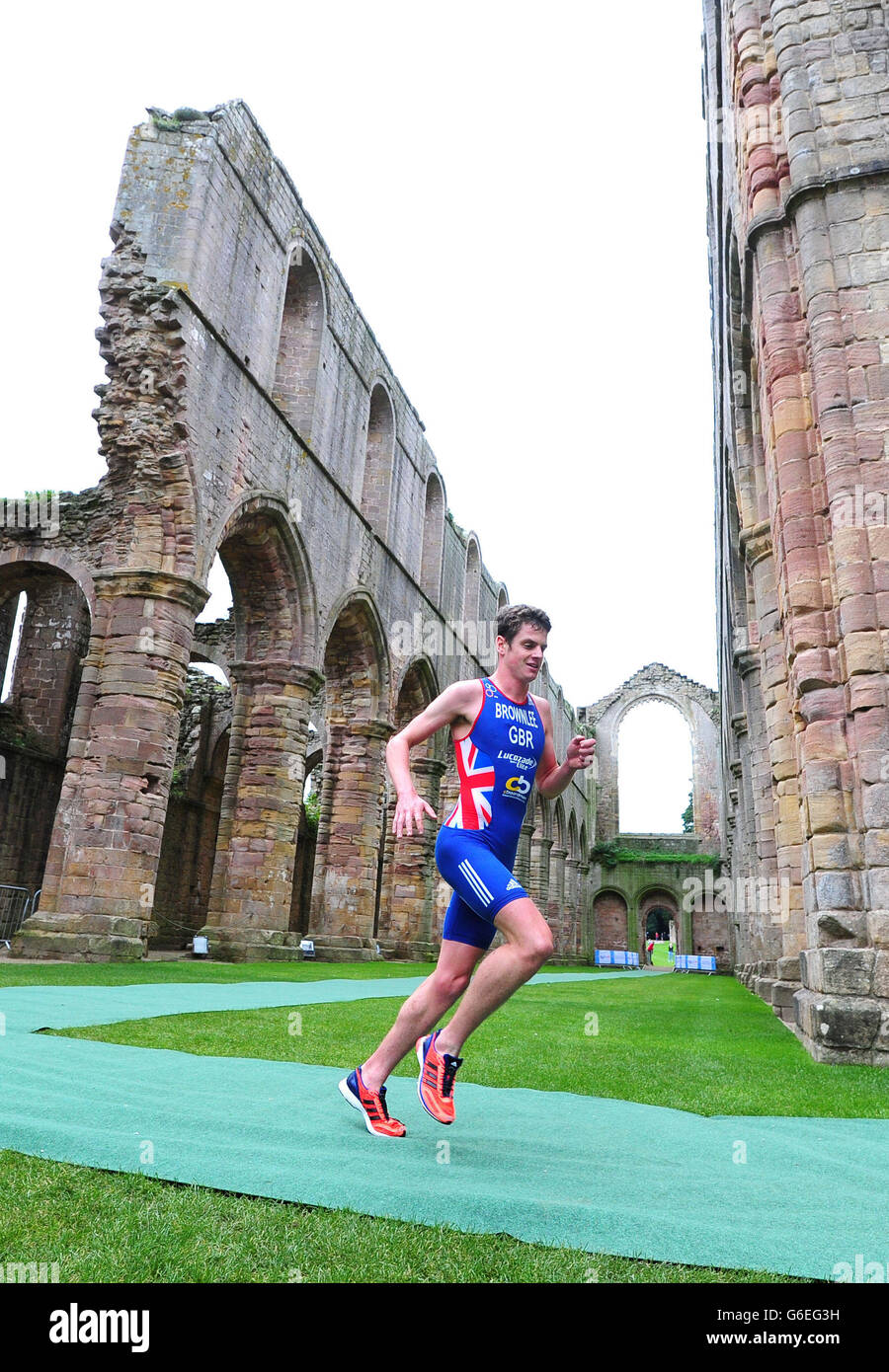 Jonathan Brownlee court à travers les ruines de l'abbaye sur son chemin pour gagner le Brownlee Tri à Fountains Abbey, Ripon. Banque D'Images