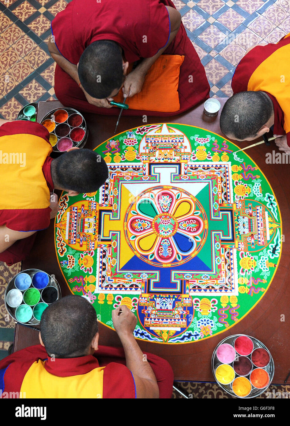 (Dans le sens des aiguilles d'une montre à partir de la gauche) Kachen Choedrak, Ven Lobzang Thokmed, Kachen Namgyal et Kachen Lobzang Tuskhor, moines du monastère de Tashi Lhunpo, faisant un Mandala de sable de Chenrezig de compassion et de bonté dans le Chapitre House de la cathédrale de Salisbury. Banque D'Images