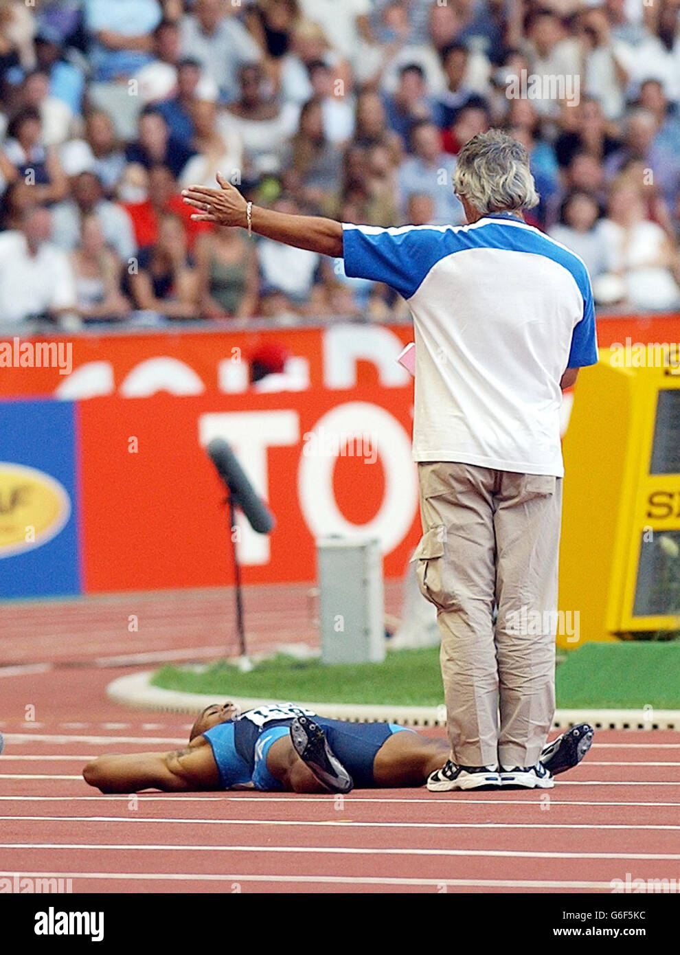 Jon Drummond (en bas) des États-Unis se trouve sur le dos, refusant de sortir de la piste après qu'il ait été disqualifié dans le quart-finale du 100m masculin aux Championnats du monde d'athlétisme à Paris, en France, le dimanche 24 août 2003. Banque D'Images
