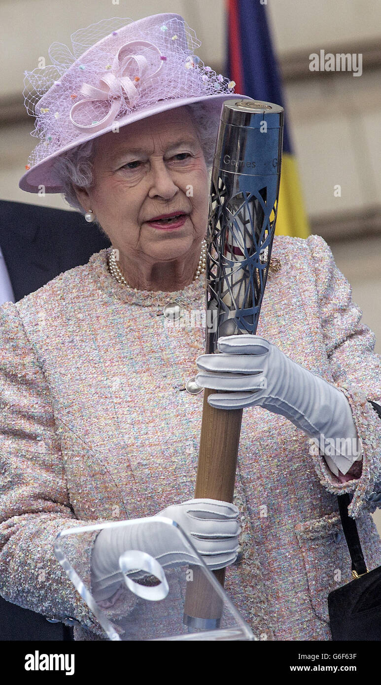La reine Elizabeth II se dresse devant les drapeaux du Commonwealth lors de la cérémonie de lancement du Queen's Baton au palais de Buckingham à Londres. Banque D'Images