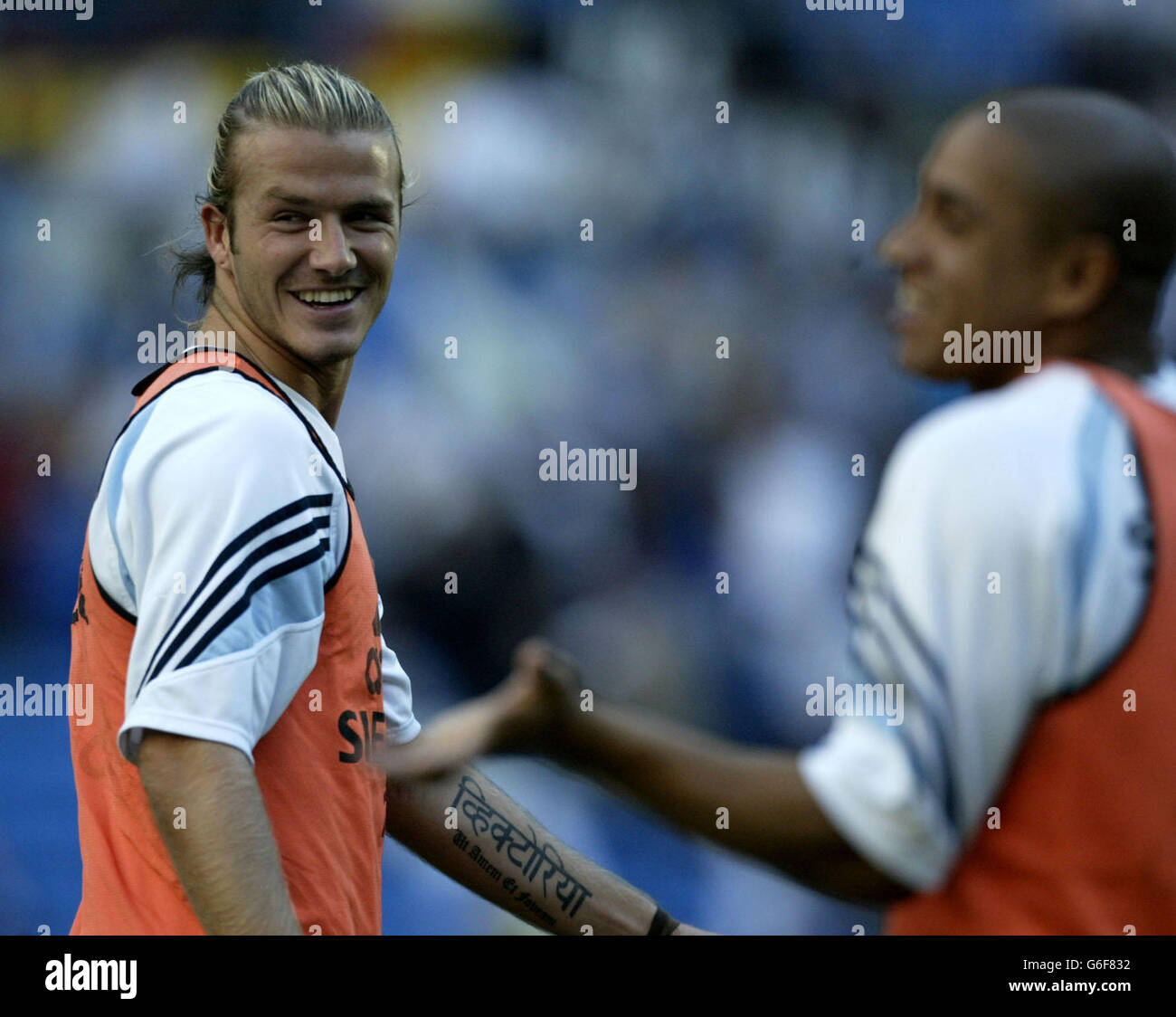 David Beckham du Real Madrid apprécie les blagues avec Roberto Carlos (à droite) lors de l'échauffement avant son premier match de la Ligue espagnole contre Real Betis, que le Real Madrid a remporté en 2.1, lors du match de la Ligue espagnole Primera au stade Bernabeu à Madrid, en Espagne. Banque D'Images