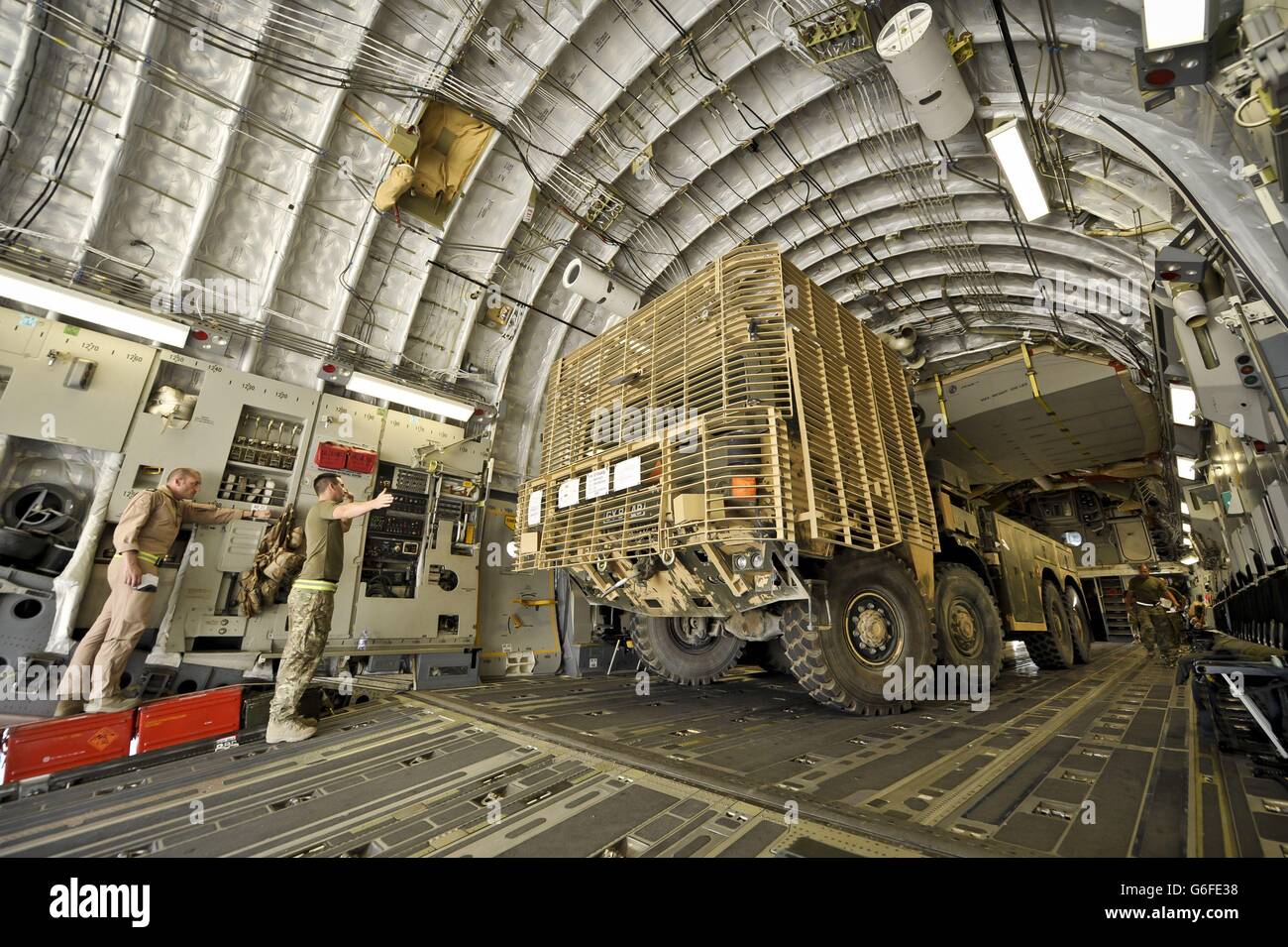 Un camion lourd de combat à huit roues, équipé d'une armure de barre, est renversé et chargé sur un C-17 sur la piste du Camp Bastion, province d'Helmand, Afghanistan, Où il reviendra au Royaume-Uni dans le cadre du redéploiement de l'équipement du théâtre au fur et à mesure que le retrait progresse, prêt pour le retrait total des forces britanniques en 2014. Banque D'Images