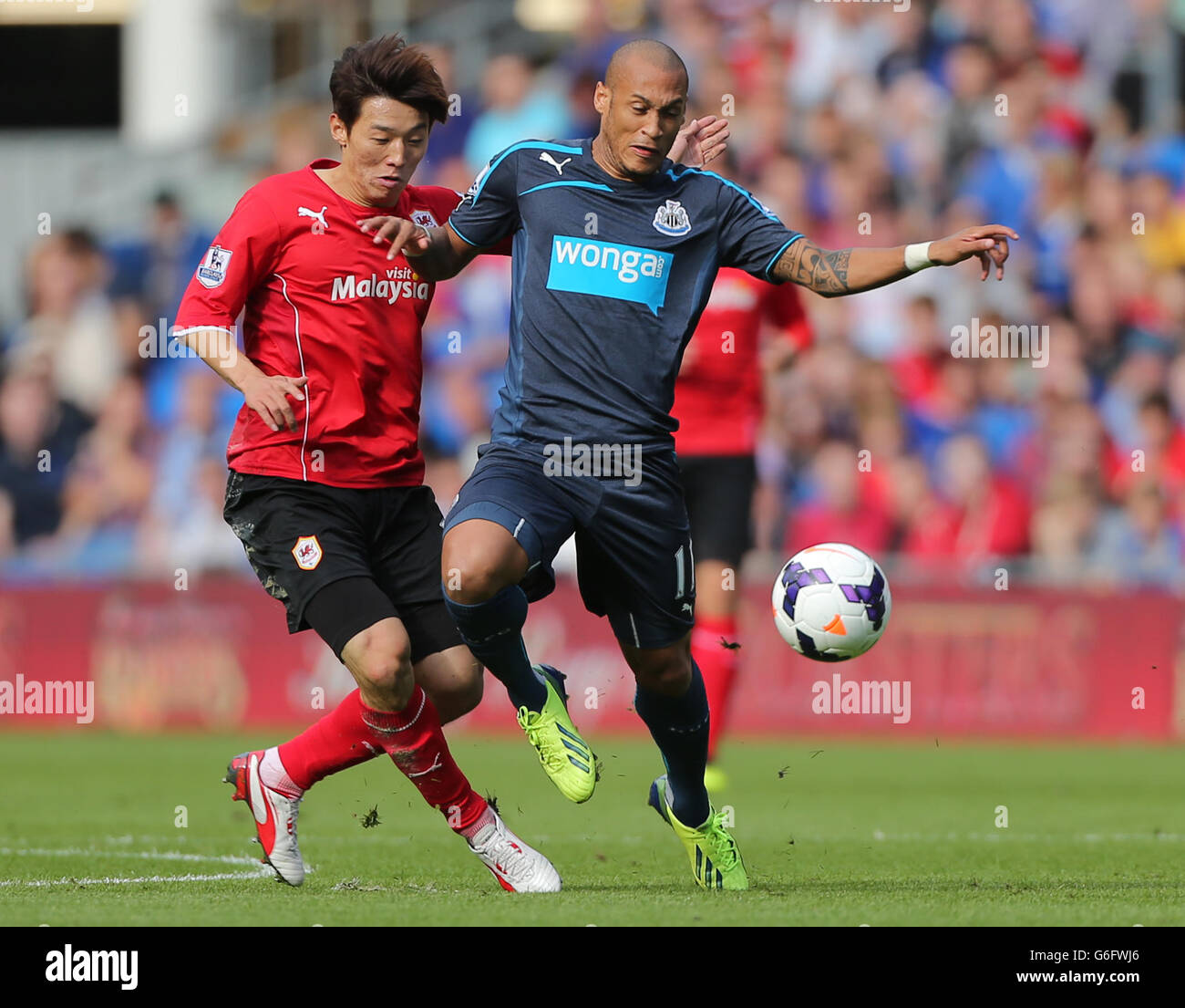 Yoan Gouffran, de Newcastle United, détient KIM Bo-Kyung, de Cardiff City, lors du match de la Barclays Premier League au Cardiff City Stadium, à Cardiff. Banque D'Images