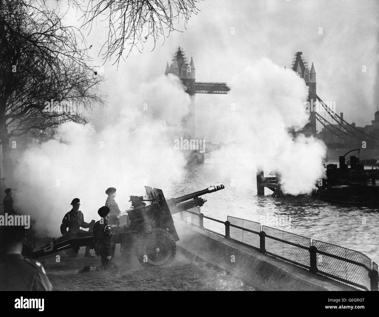 Marquant l'anniversaire de l'accession du roi George VI au trône il y a quatorze ans, la batterie 'A', 1er Régiment, l'hon. Artillery Company, a tiré un hommage de 62 armes à feu à la Tour de Londres. Tower Bridge peut être vu en arrière-plan à travers la fumée. Banque D'Images