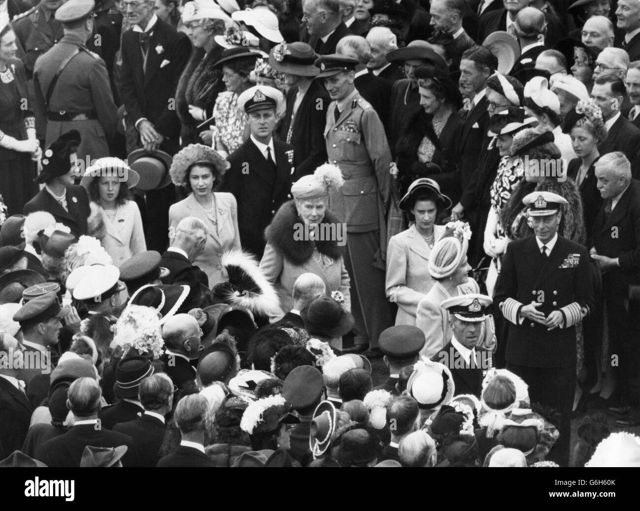 Passant entre les invités assemblés à la fête du jardin, le Roi et la Reine sont suivis de la princesse Margaret et de la reine Mary, de la princesse Elizabeth et de Lieut.Philip Mountbattem, la duchesse de Kent et la princesse Alexandra. Banque D'Images