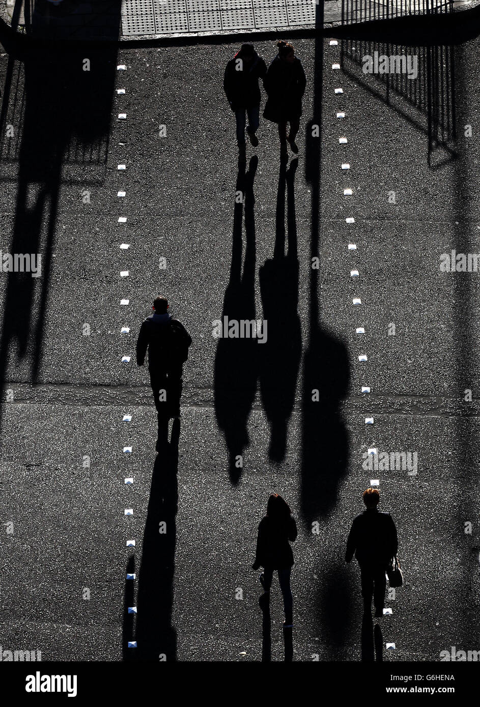 De longues ombres sont projetées dans le soleil d'automne tandis que les gens traversent Lothian Road à Édimbourg. Banque D'Images