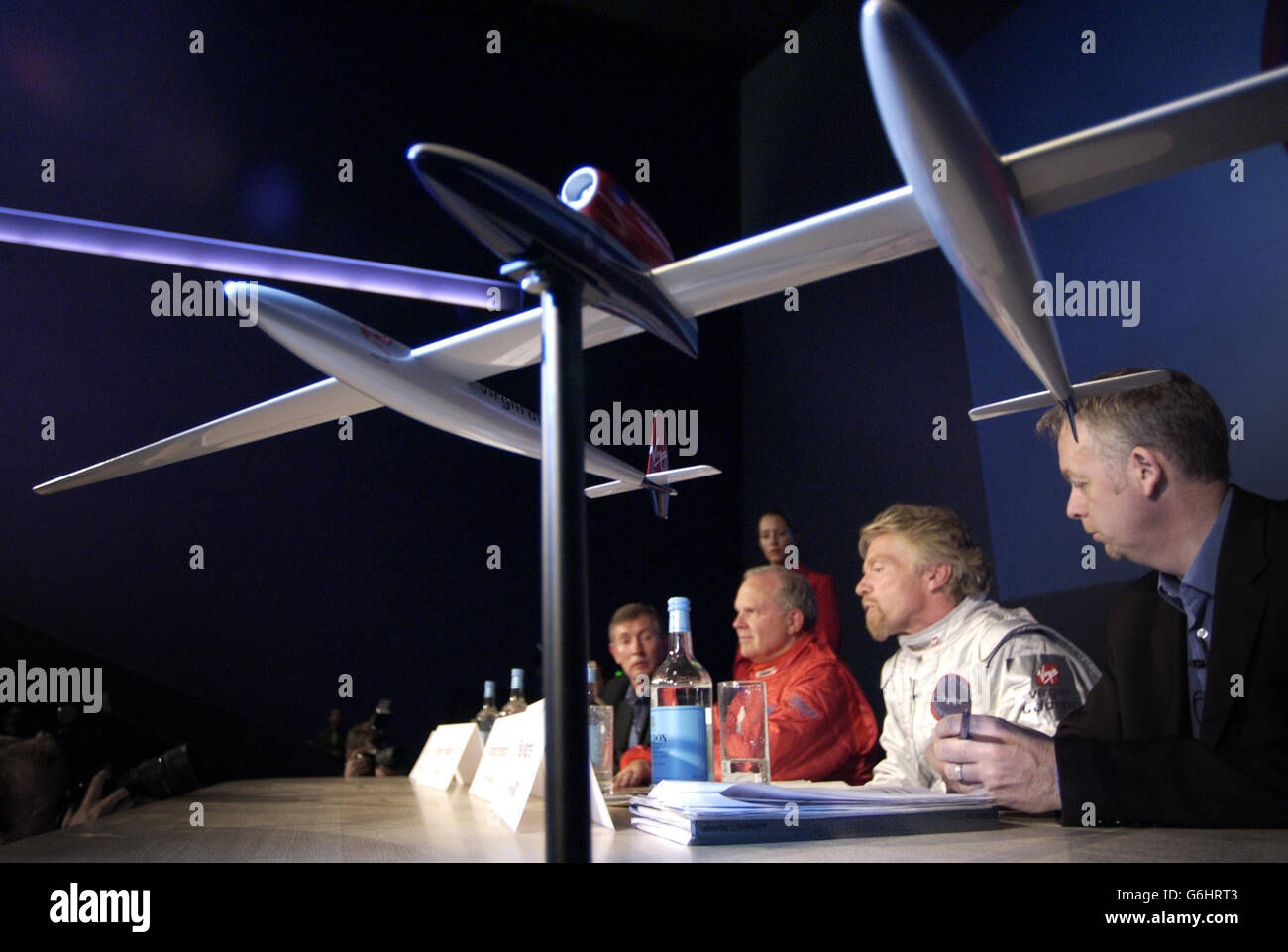 Steve Fossett (assis, troisième à droite) et Sir Richard Branson (deuxième à droite) s'assoient au Musée des sciences de Londres avec un modèle (au premier plan) du GlobalFlyer de Virgin Atlantic qu'ils espèrent devenir le premier avion à être piloté seul dans le monde entier.L'avion de 285 km/h, qui pourrait effectuer un voyage autour du monde en 80 heures et voler à une altitude de plus de 50 000 pieds, sera piloté soit par le détenteur du record Steve Fossett, qui était le partenaire de Sir Richard lors de sa dernière tentative de vol en montgolfière mondiale, soit par Sir Richard, qui sera pilote de réserve. Banque D'Images