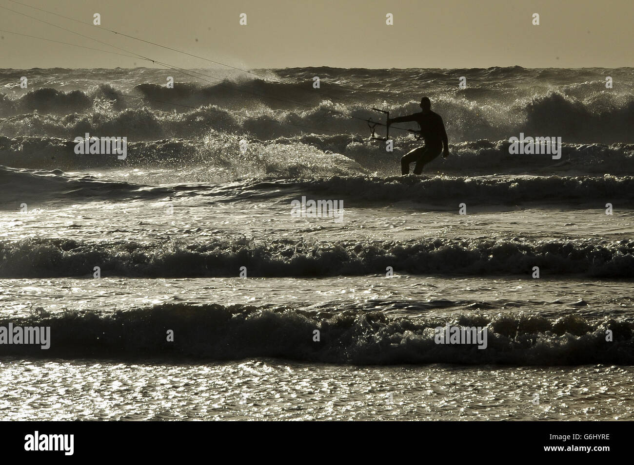 Un surfeur de cerf-volant peut faire le maximum des vents forts et du temps de tempête spectaculaire à Rest Bay, Porthcawl, pays de Galles. Banque D'Images
