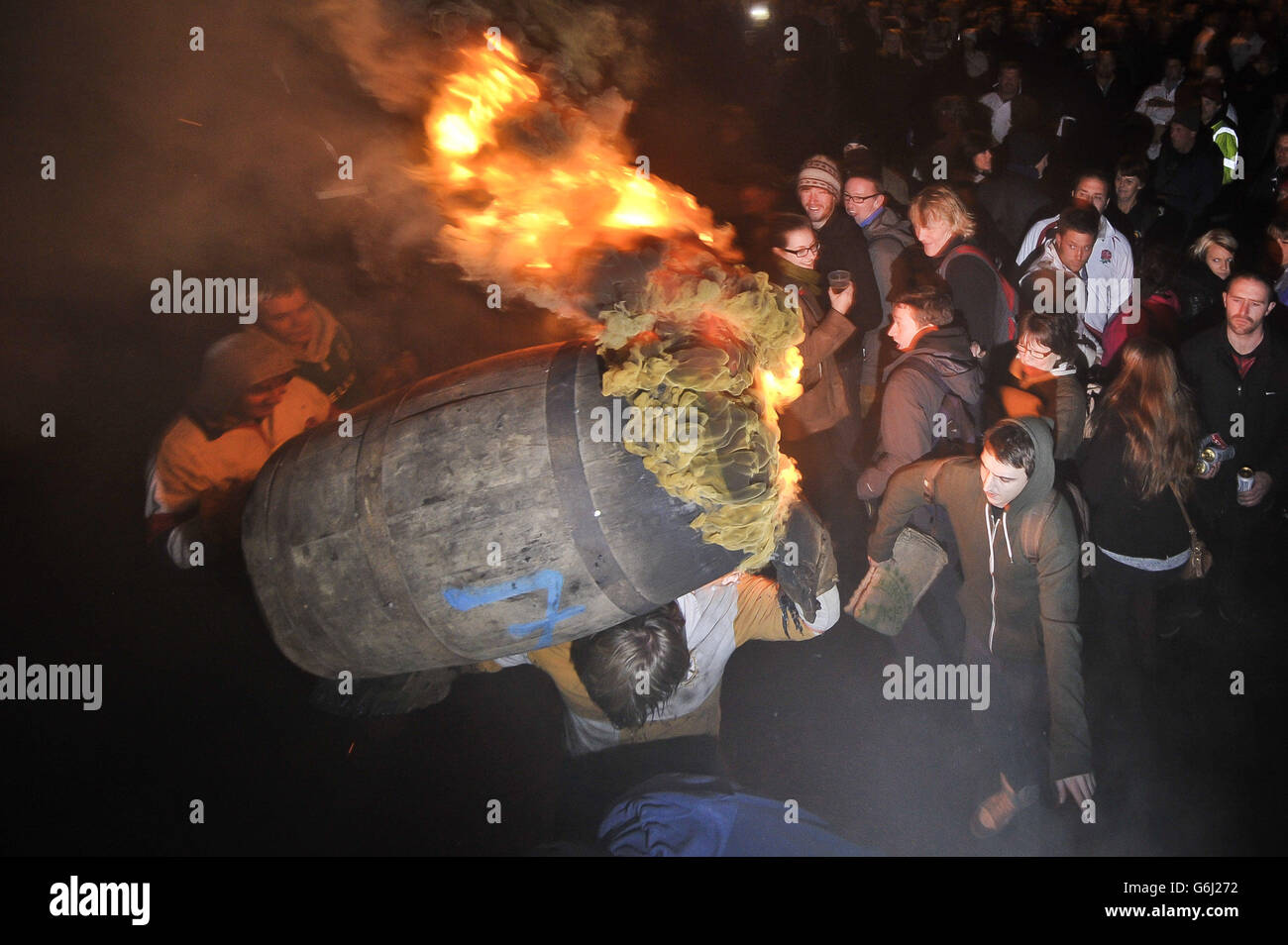 Les adultes du village Devonshire d'Ottery St Mary portent le Tar Barrel traditionnel à travers les rues du village la nuit de Bonfire. Banque D'Images